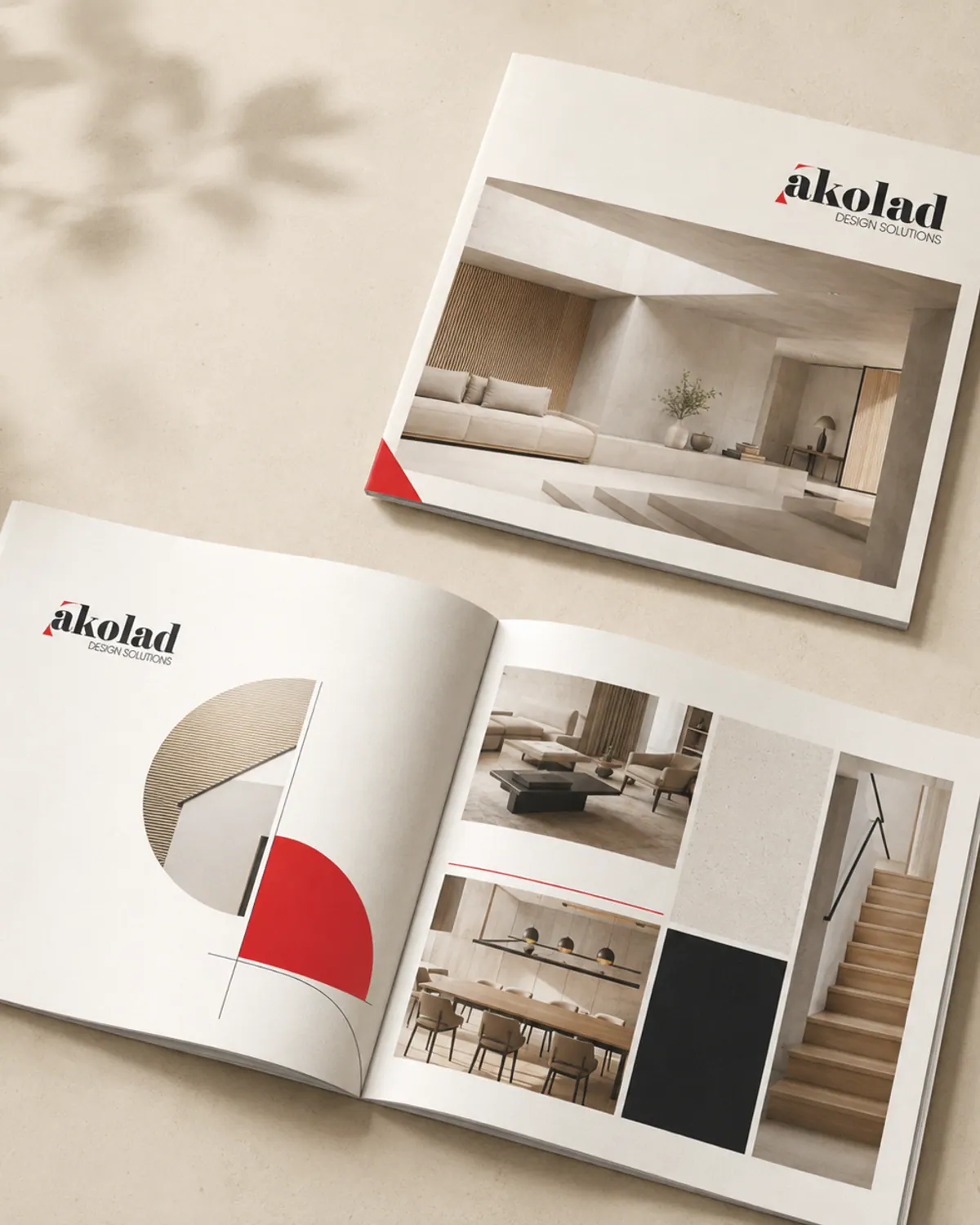 A landscape brochure lying open beside a closed copy, showing an interior photograph on the cover.